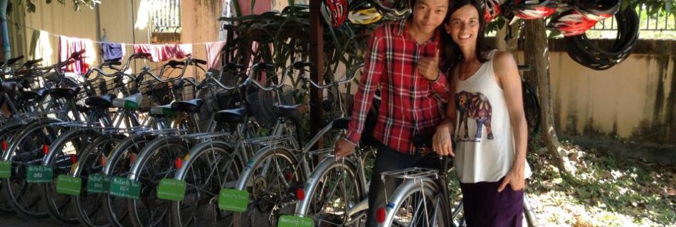 Mujer argentina con vestimenta yogui posando junto a asiatico que alquila bicicletas
